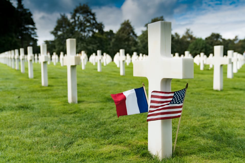 French And American Flags At Base Of White Cross