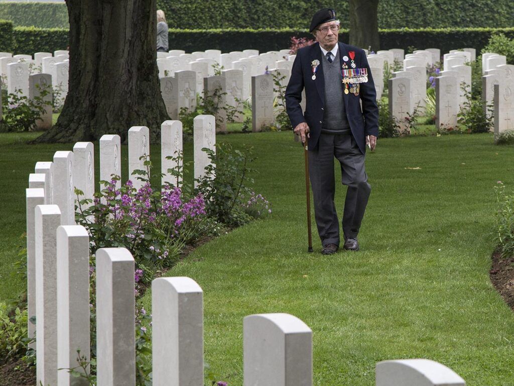 Veteran Walking Through The Bayeux War Cemetery