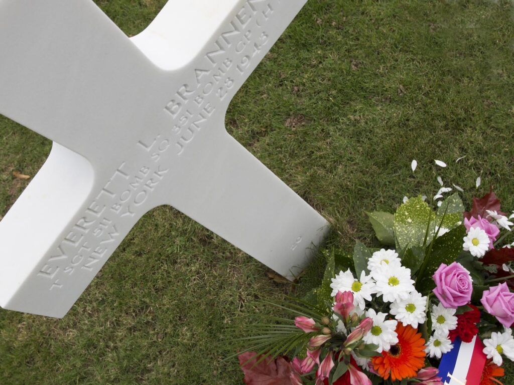 White Cross With Flowers At Brittany American Cemetery At Saint James